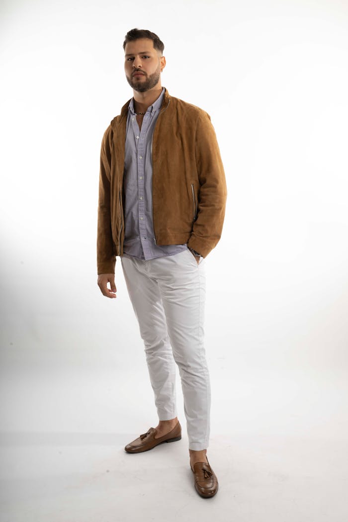 gallery-5 A fashionable young man poses confidently in casual attire against a plain studio background.