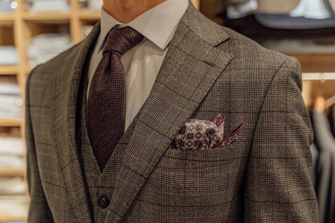 gallery-3 Close-up of a tailored suit showcased in a fashion boutique, highlighting intricate patterns and style.